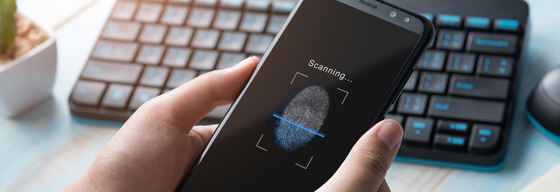 Bild eines Smartphones mit Fingerabdruck-Scanner vor einer Tastatur