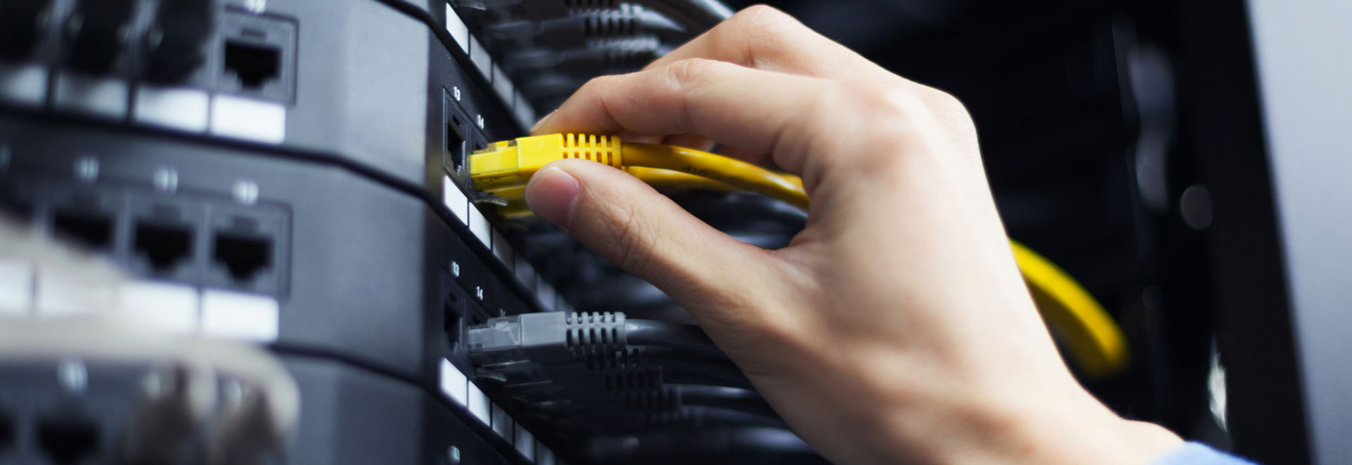 Hand steckt ein LAN-Kabel in den passenden Anschluss