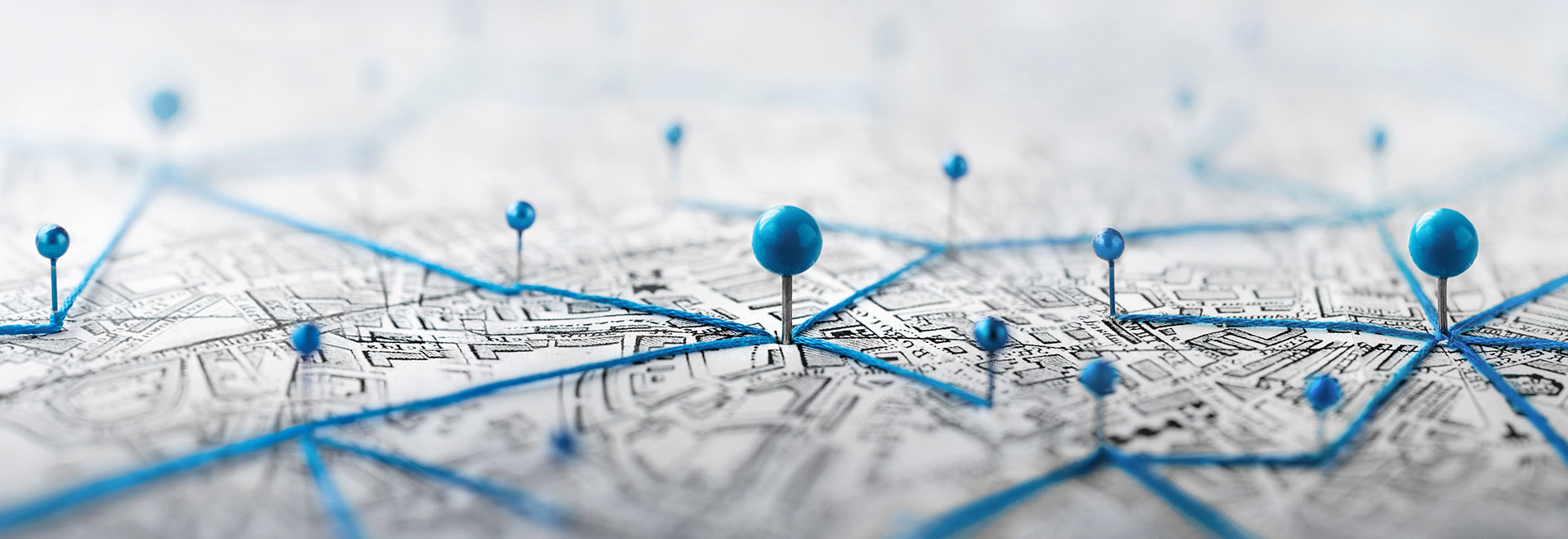 Stadtplan mit blauen Stecknadeln, die mit blauen Fäden verbunden sind
