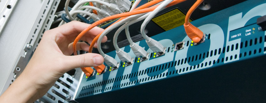 Hand steckt ein Netzwerkkabel in einen Server