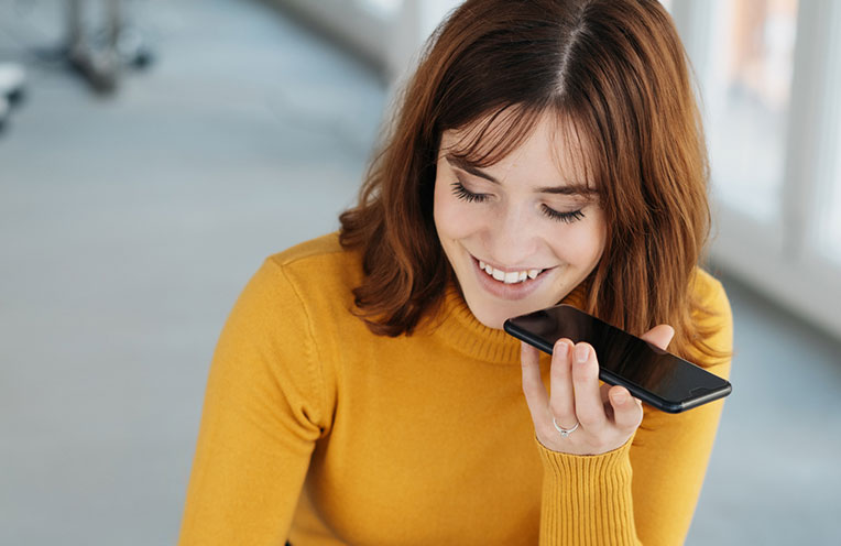 Junge Frau spricht in ihr Smartphone