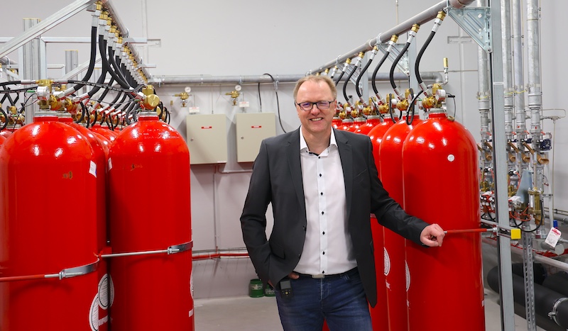 Das DOKOM21 Rechenzentrum verfügt u. a. über eine moderne Gaslöschanlage Mann vor Löschgasflaschen