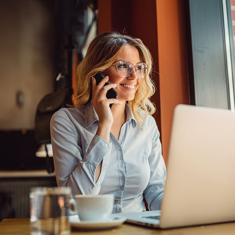 Reibungslose Kundenkommunikation dank DOKOM21 Mobilfunk Frau arbeitet und telefoniert und in einem Café