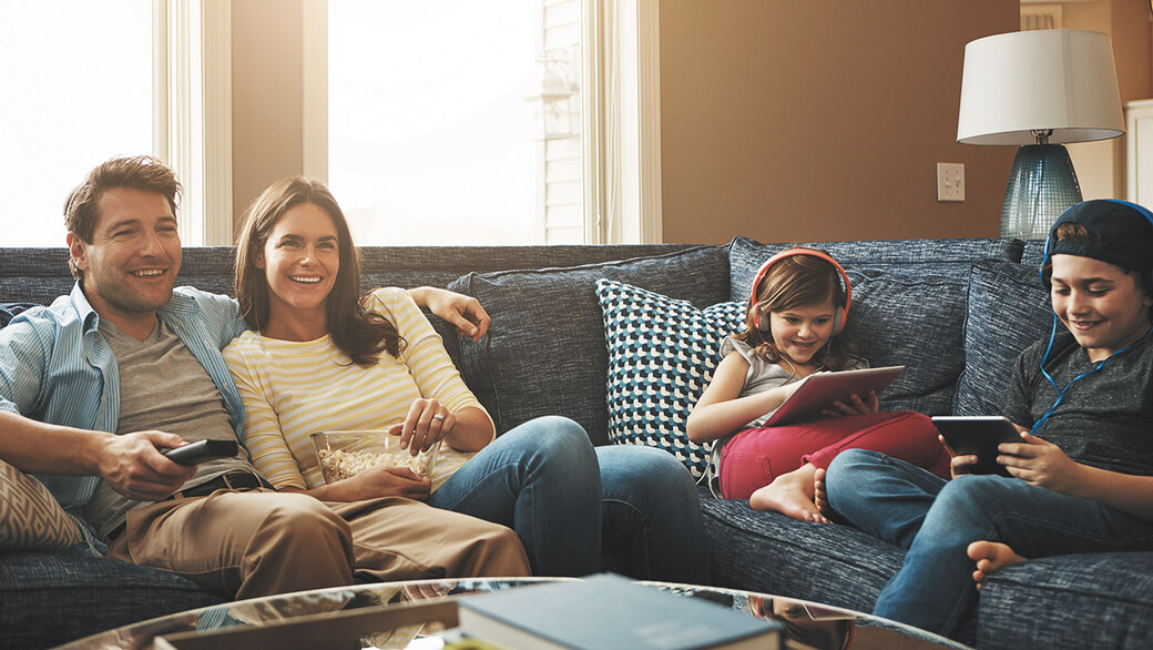 Familie vor Fernseher und Tablet